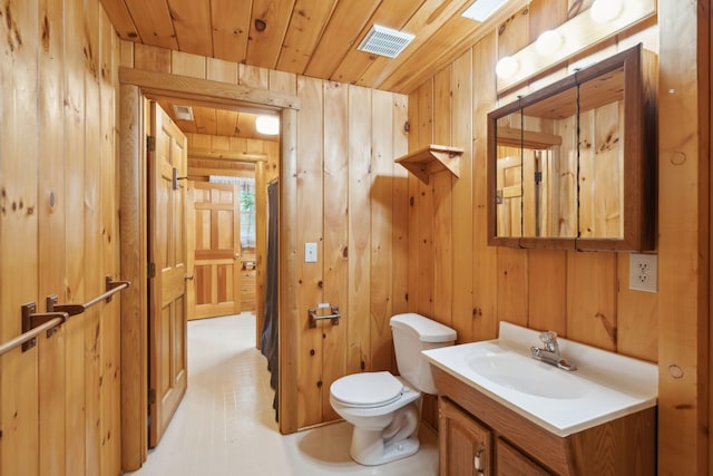 bathroom with vanity, wooden walls, wood ceiling, and toilet