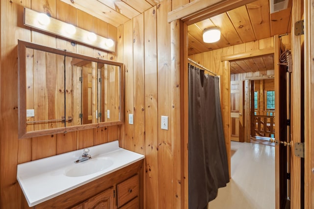 bathroom featuring vanity, curtained shower, wooden ceiling, and wood walls