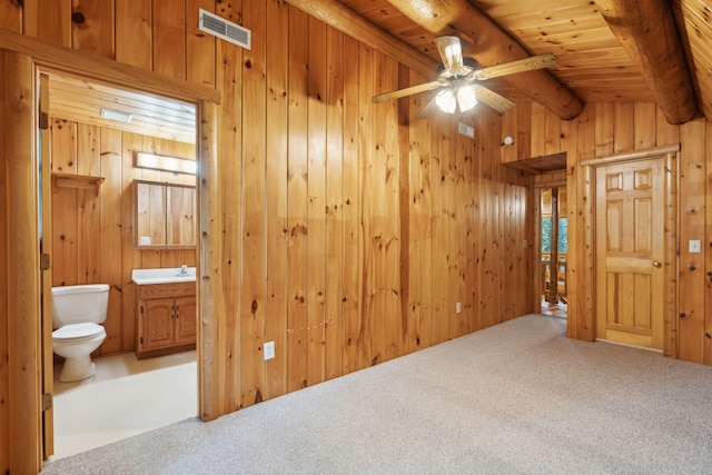 interior space featuring vaulted ceiling with beams, wooden walls, and carpet flooring