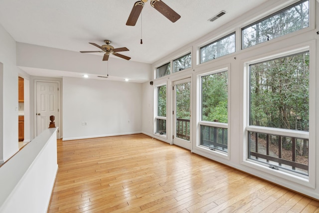 unfurnished sunroom featuring plenty of natural light and light hardwood / wood-style flooring