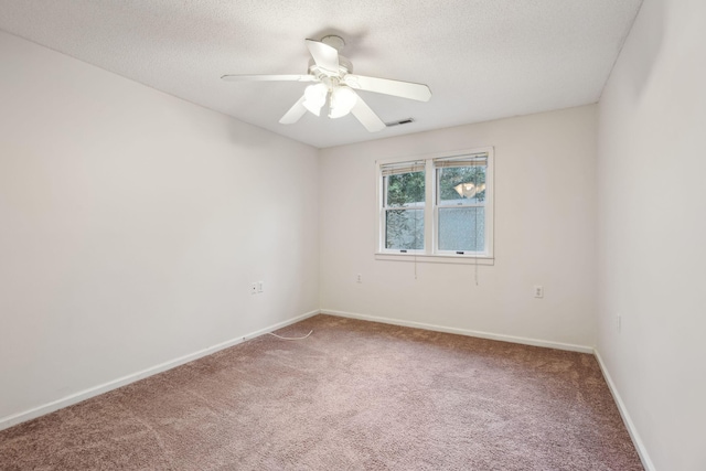 carpeted empty room with ceiling fan and a textured ceiling