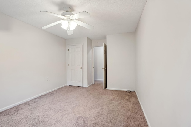 carpeted empty room with ceiling fan and a textured ceiling