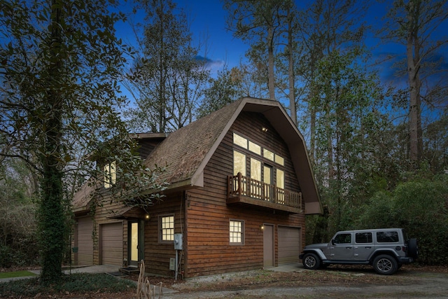 view of side of property featuring a balcony and a garage