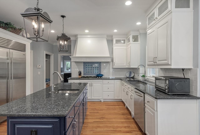 kitchen featuring custom exhaust hood, a sink, appliances with stainless steel finishes, a chandelier, and recessed lighting