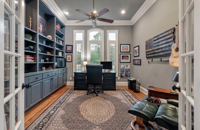 office area featuring light wood-style floors, ornamental molding, a ceiling fan, and baseboards