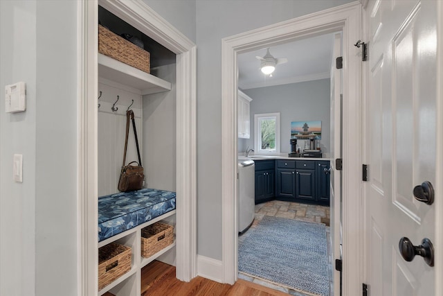 mudroom featuring a sink, baseboards, ornamental molding, and washer / clothes dryer
