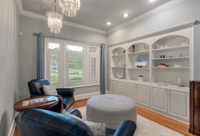 living area with a chandelier, light wood-type flooring, ornamental molding, built in shelves, and baseboards