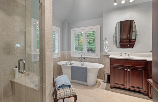 bathroom featuring a stall shower, tile patterned floors, a freestanding tub, tile walls, and lofted ceiling