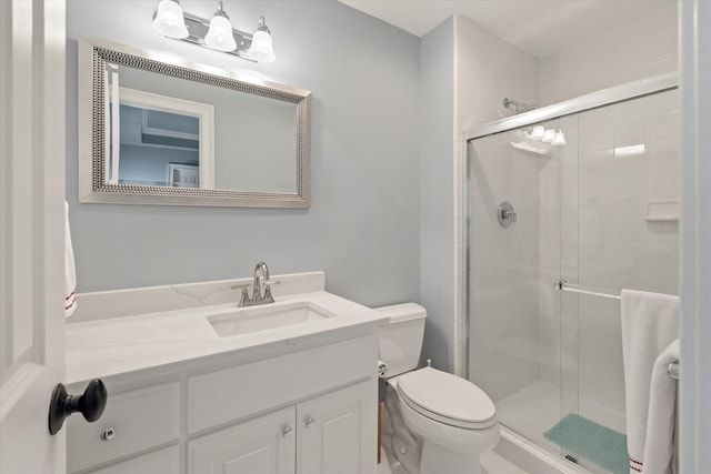 full bath with a stall shower, toilet, and vanity