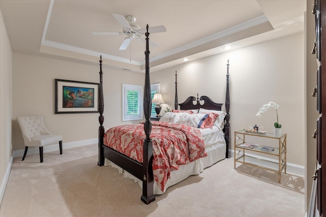 bedroom with a raised ceiling, ornamental molding, light carpet, baseboards, and ceiling fan