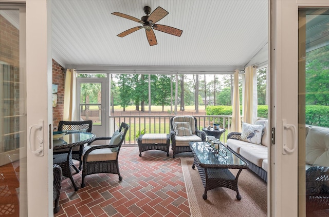 sunroom / solarium featuring a ceiling fan, vaulted ceiling, plenty of natural light, and outdoor lounge area