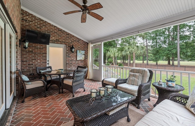 sunroom / solarium with a ceiling fan, lofted ceiling, and an outdoor hangout area