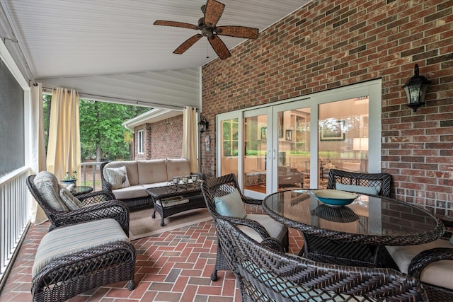 sunroom / solarium featuring french doors, outdoor lounge area, ceiling fan, and vaulted ceiling