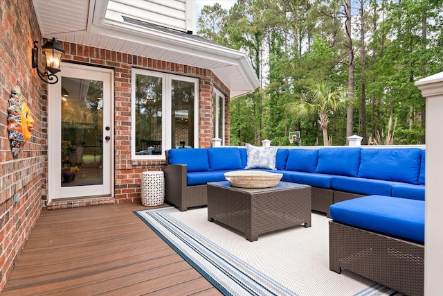 deck with outdoor lounge area and view of wooded area