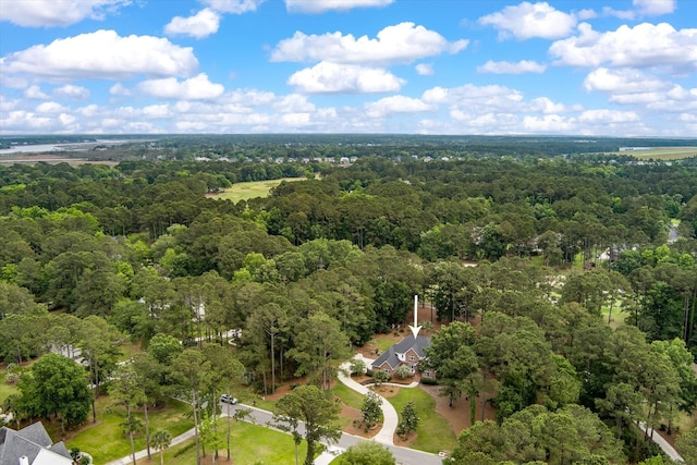 aerial view of property and surrounding area with a heavily wooded area