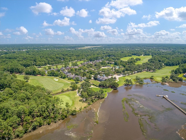 bird's eye view of a golf club, a large body of water, and a forest