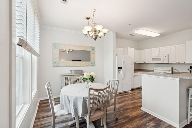 dining area with a wealth of natural light, ceiling fan with notable chandelier, and dark hardwood / wood-style floors