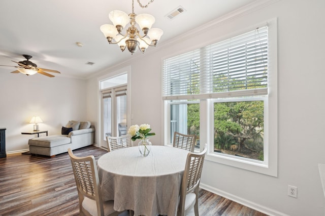 dining room with ceiling fan with notable chandelier, crown molding, and dark wood-type flooring