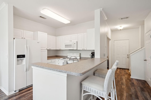 kitchen with kitchen peninsula, white cabinetry, dark hardwood / wood-style floors, and white appliances