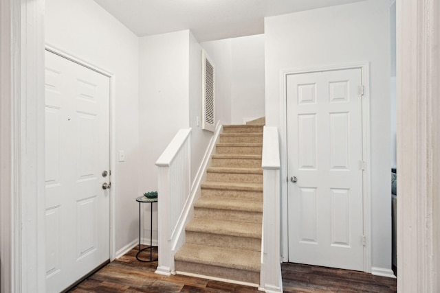 stairs featuring hardwood / wood-style floors