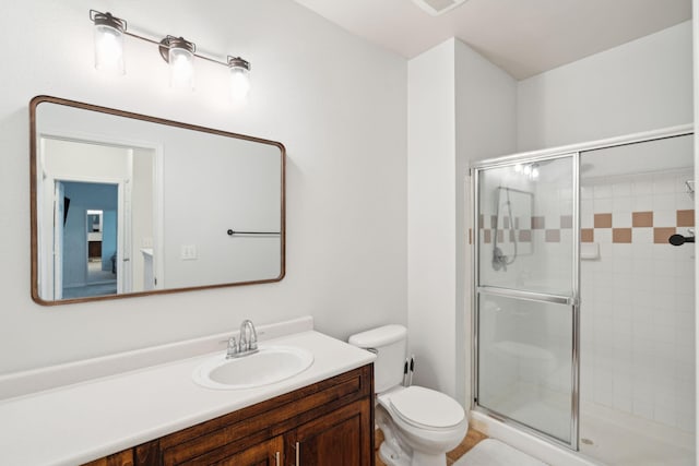 bathroom with vanity, an enclosed shower, and toilet