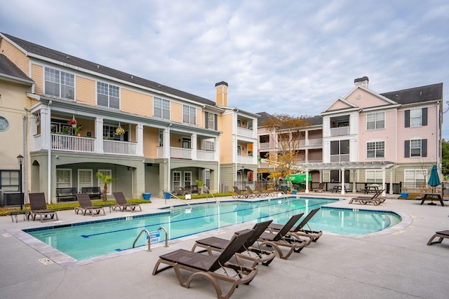 view of swimming pool featuring a pergola, a patio, and central air condition unit