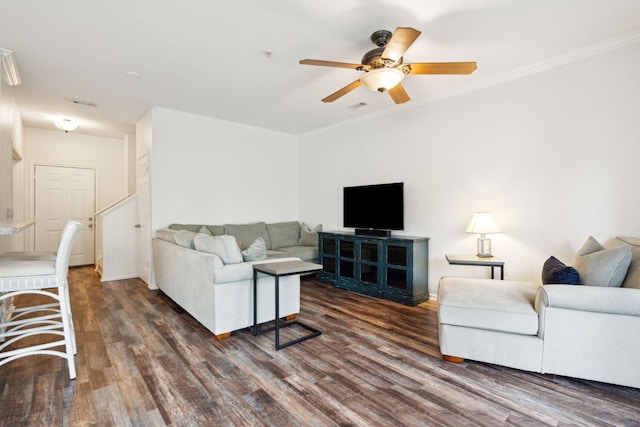 living room with dark hardwood / wood-style flooring, ceiling fan, and crown molding