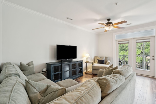 living room featuring crown molding, light hardwood / wood-style flooring, and ceiling fan