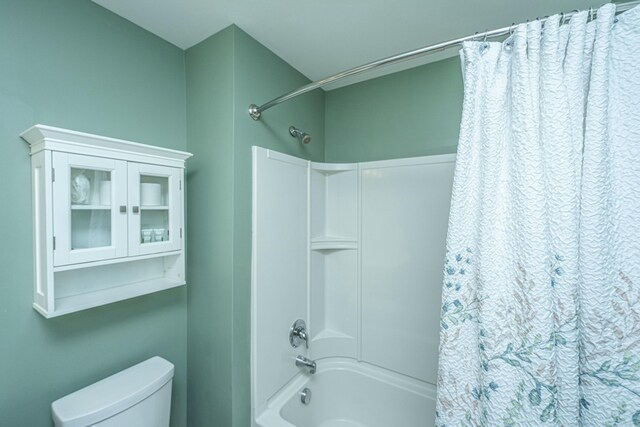 bathroom featuring shower / tub combo with curtain and toilet