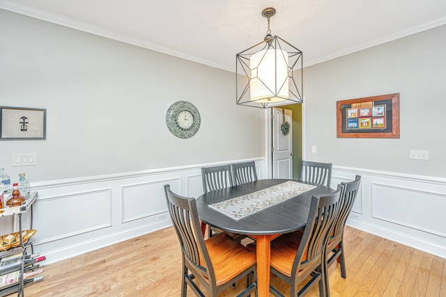 dining space featuring an inviting chandelier, crown molding, and light hardwood / wood-style flooring