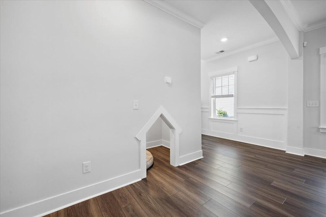 unfurnished room with visible vents, ornamental molding, arched walkways, baseboards, and dark wood-style flooring