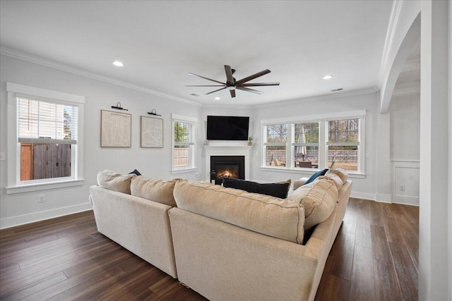 living room with plenty of natural light, dark wood-type flooring, and a glass covered fireplace