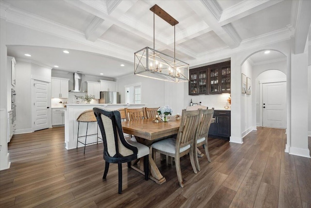 dining area featuring dark wood-type flooring, coffered ceiling, and beam ceiling