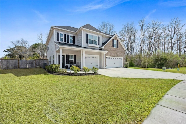 traditional-style home featuring driveway, fence, covered porch, a front yard, and an attached garage