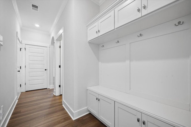 mudroom featuring visible vents, crown molding, baseboards, and dark wood-style flooring