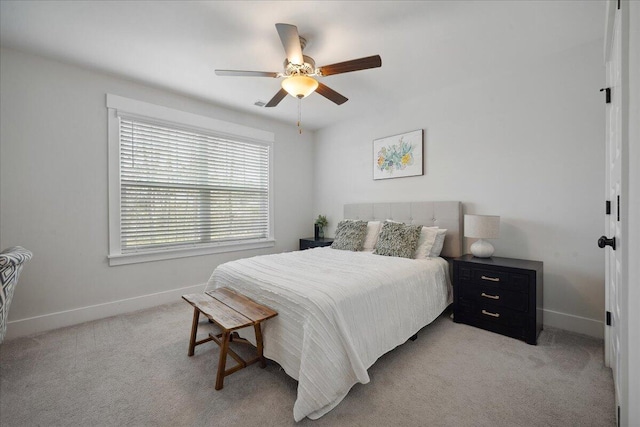 bedroom featuring light colored carpet, a ceiling fan, and baseboards