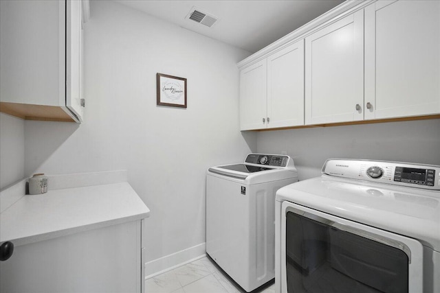 laundry room featuring visible vents, baseboards, cabinet space, separate washer and dryer, and marble finish floor