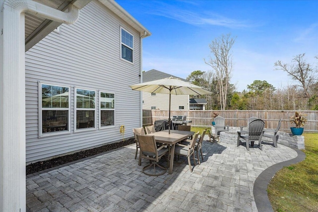 view of patio featuring an outdoor fire pit, outdoor dining area, fence, and a grill