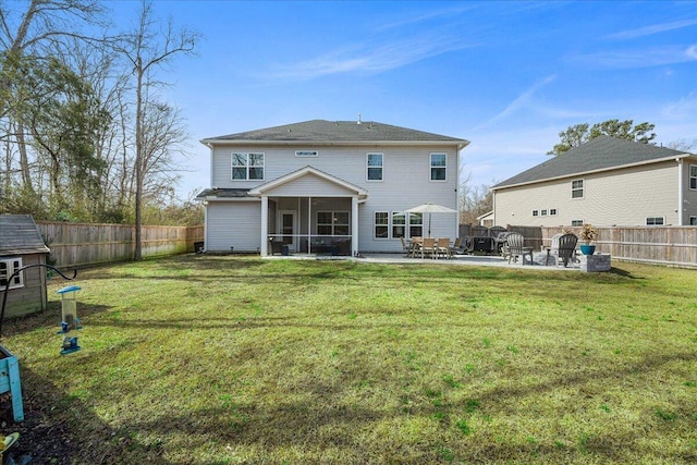 back of house featuring a patio area, a lawn, a fenced backyard, and a sunroom