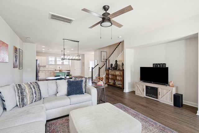 living room featuring ceiling fan and dark hardwood / wood-style flooring