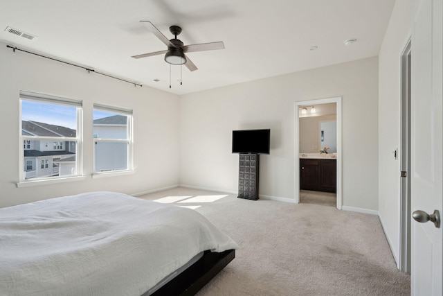 carpeted bedroom featuring ensuite bath and ceiling fan