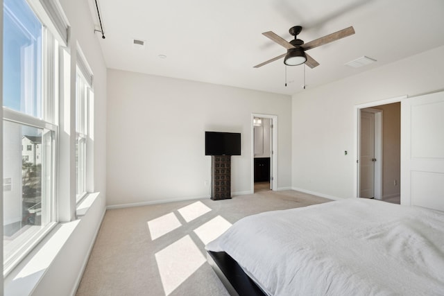 carpeted bedroom with ceiling fan and ensuite bath