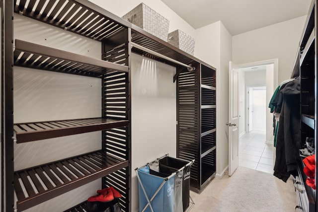 walk in closet featuring light colored carpet