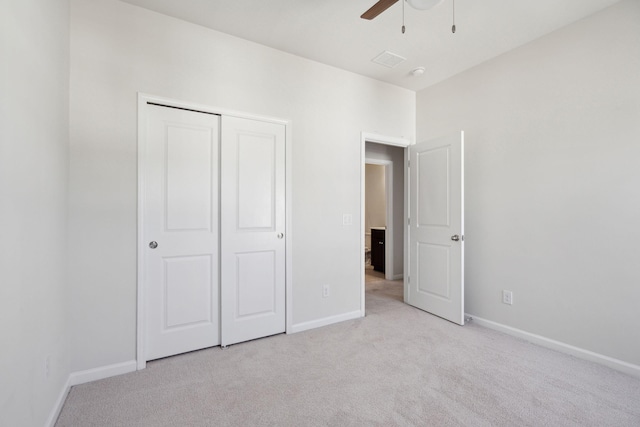 unfurnished bedroom featuring light colored carpet, ceiling fan, and a closet