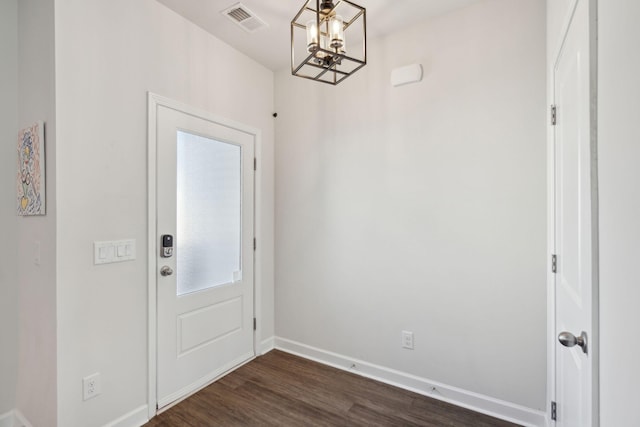 entryway with dark hardwood / wood-style flooring and a notable chandelier