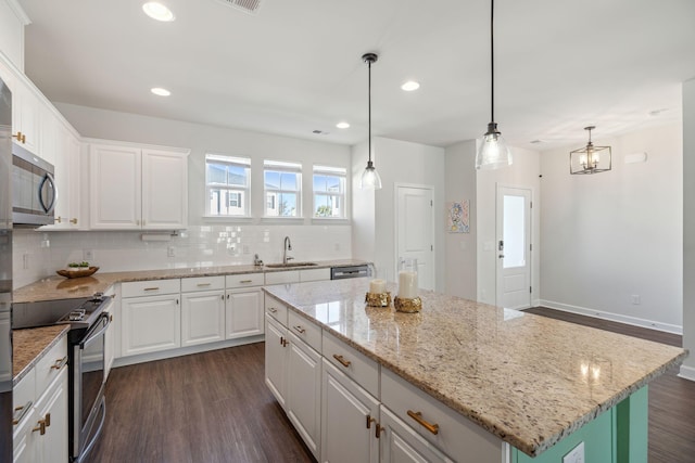 kitchen with stainless steel appliances, a center island, sink, and white cabinets