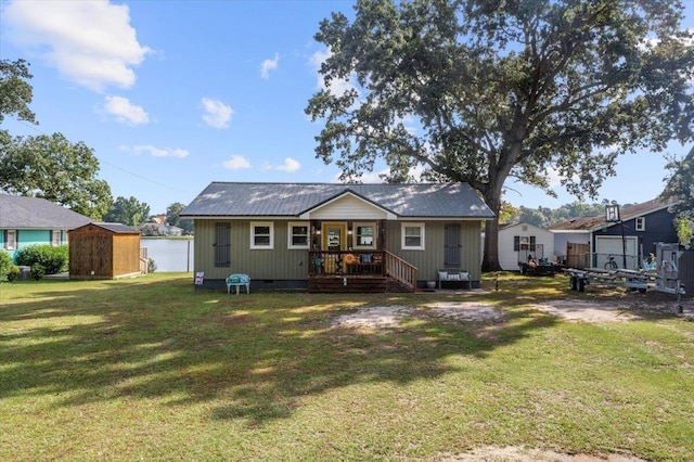 back of house featuring a lawn and a storage shed