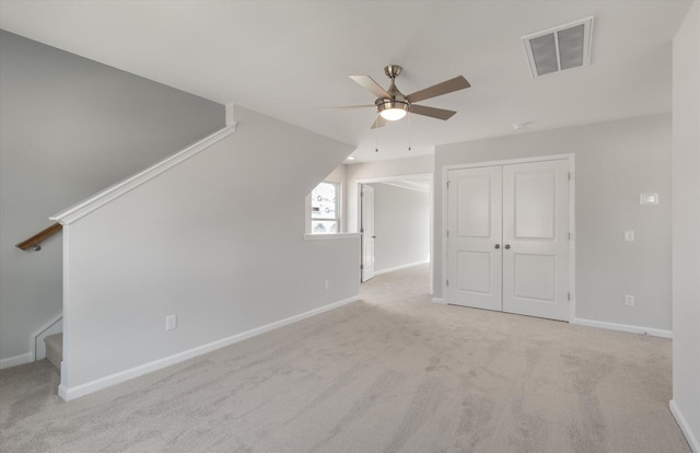 bonus room with carpet floors, a ceiling fan, visible vents, baseboards, and stairway