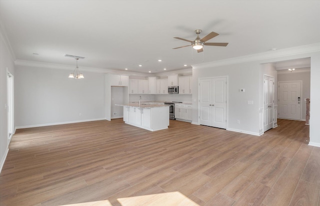 kitchen featuring light wood finished floors, white cabinetry, appliances with stainless steel finishes, and open floor plan