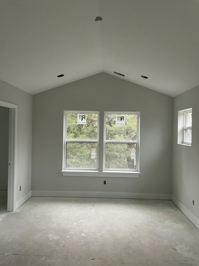 unfurnished room featuring lofted ceiling, visible vents, and baseboards